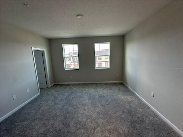 carpeted spare room featuring a textured ceiling