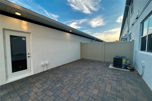 patio terrace at dusk featuring central AC unit