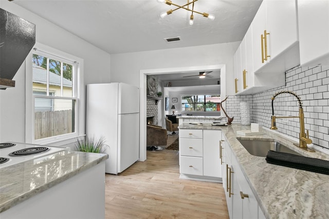 kitchen featuring light wood-type flooring, white cabinetry, white appliances, and plenty of natural light