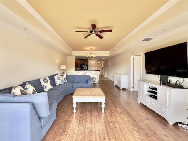 7612 Cabana Ct Unit 303, Reunion, FL 34747 - living area featuring a chandelier, ceiling fan, a tray ceiling, hardwood / wood-style floors, and crown molding