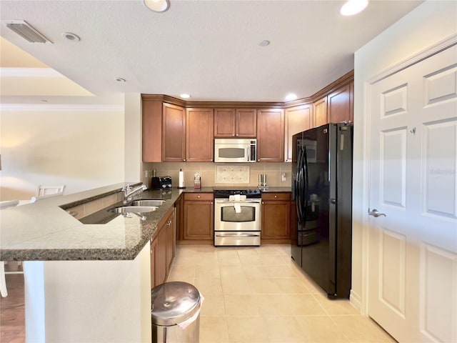 7612 Cabana Ct Unit 303, Reunion, FL 34747 - kitchen with appliances with stainless steel finishes, a peninsula, a sink, decorative backsplash, and a kitchen breakfast bar