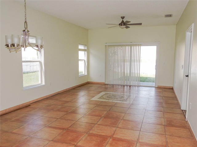 tiled spare room with ceiling fan with notable chandelier and a wealth of natural light