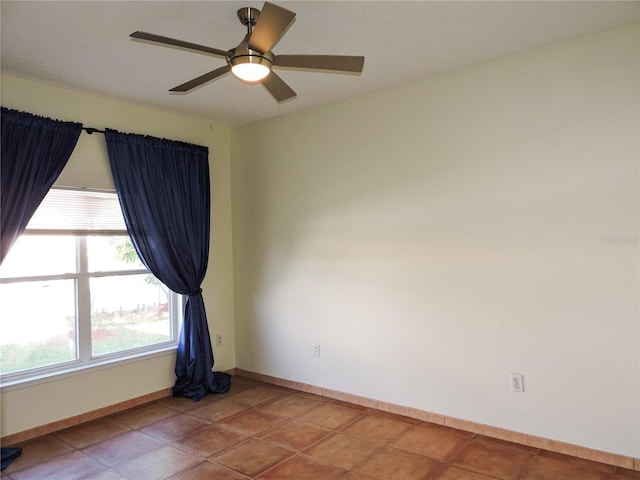 tiled empty room featuring ceiling fan