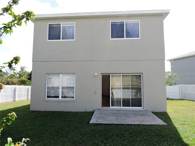 rear view of house featuring a yard and a patio