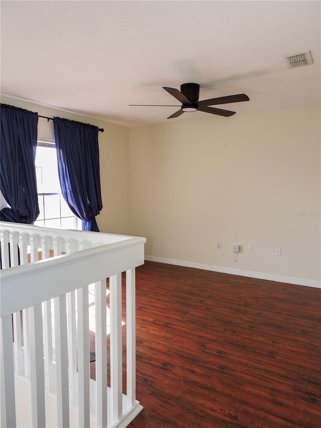 unfurnished bedroom featuring ceiling fan, dark hardwood / wood-style floors, and a textured ceiling