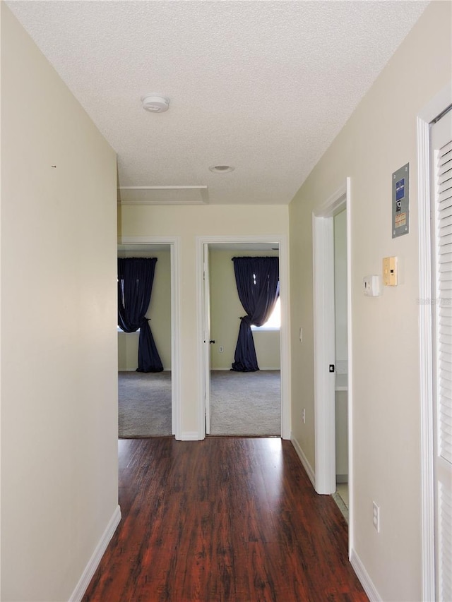 hall with dark hardwood / wood-style floors and a textured ceiling