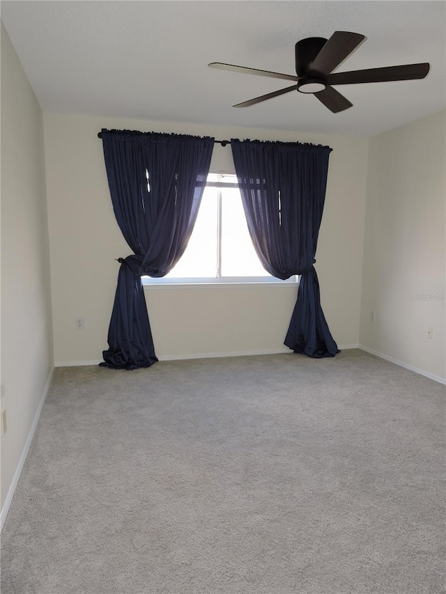 carpeted spare room with ceiling fan