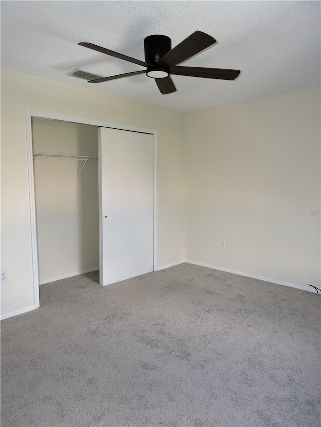 unfurnished bedroom with ceiling fan, carpet, a closet, and a textured ceiling