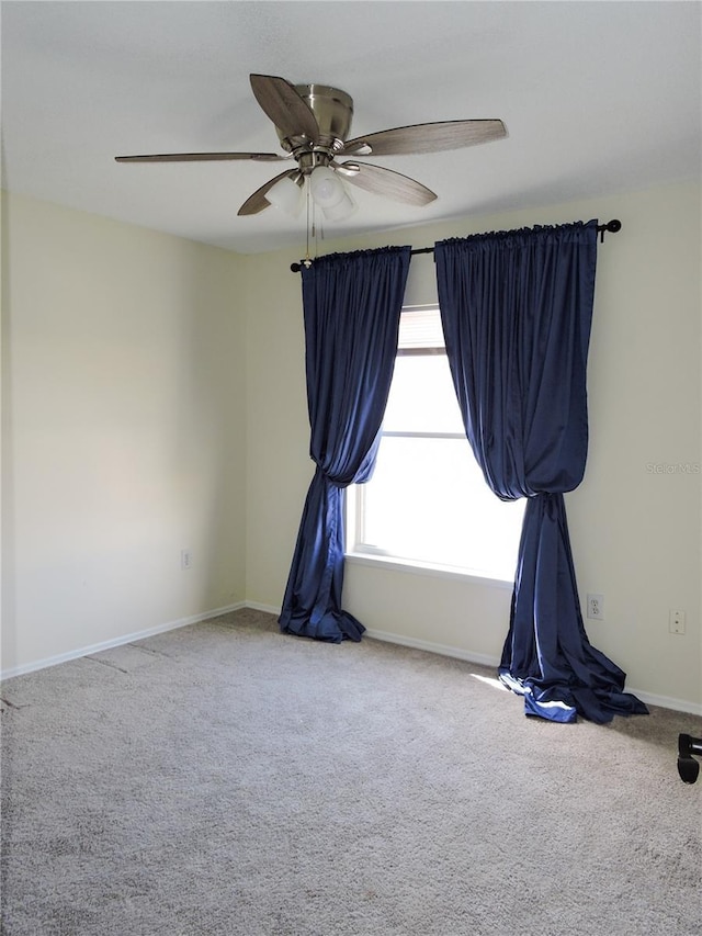 carpeted spare room with ceiling fan