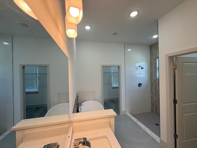 bathroom with independent shower and bath, vanity, and concrete flooring