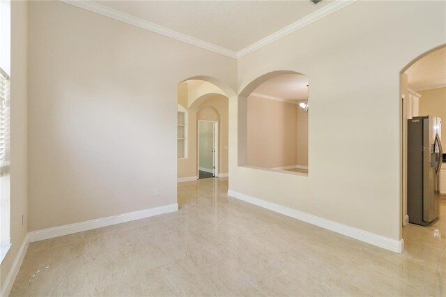 spare room with ornamental molding and a chandelier