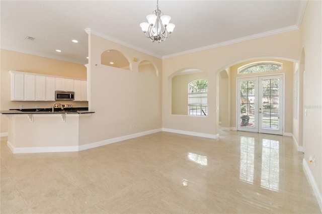 interior space with crown molding, an inviting chandelier, and french doors