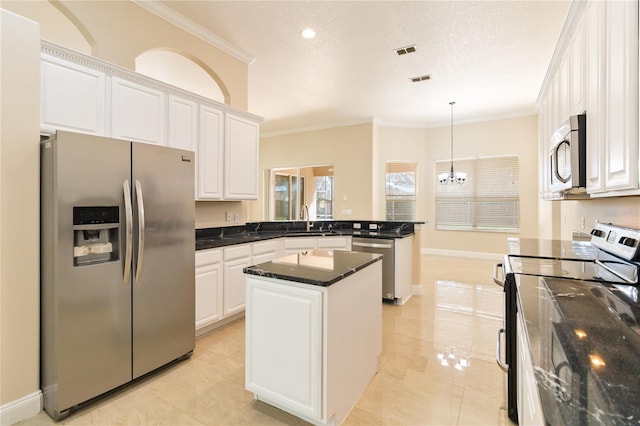 kitchen featuring sink, ornamental molding, a kitchen island, white cabinetry, and appliances with stainless steel finishes