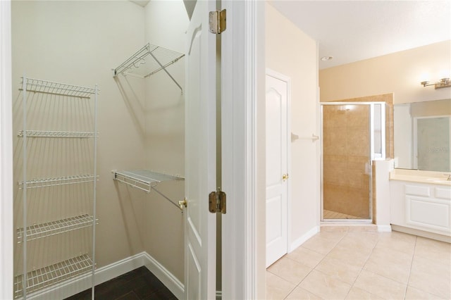 spacious closet featuring light tile patterned floors and sink