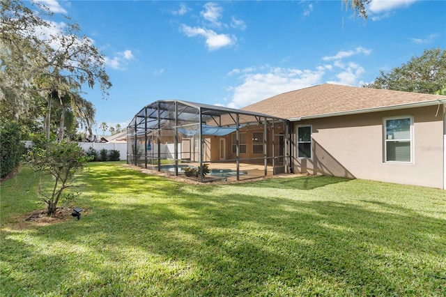 back of house with a yard, glass enclosure, and a patio area