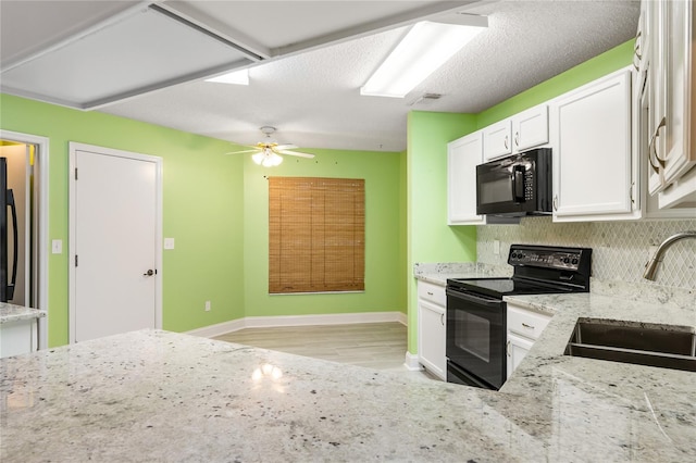 kitchen featuring white cabinetry, sink, black appliances, and light stone counters