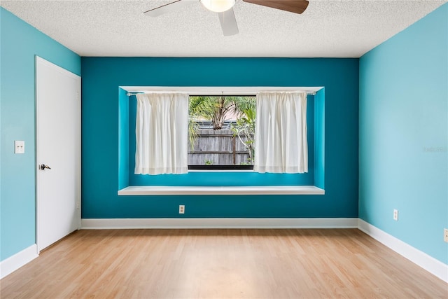 unfurnished room with ceiling fan, light hardwood / wood-style flooring, and a textured ceiling