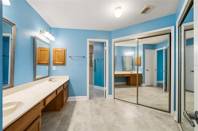 bathroom with vanity and a textured ceiling