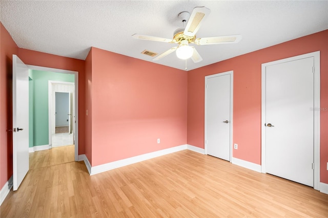 unfurnished bedroom featuring ceiling fan, light hardwood / wood-style flooring, and a textured ceiling