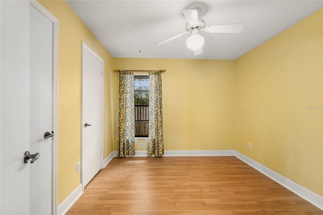 spare room with a textured ceiling, light hardwood / wood-style flooring, and ceiling fan