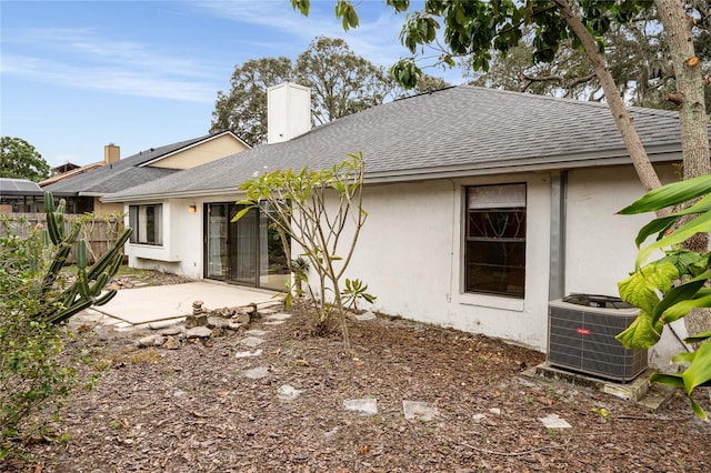 rear view of house with central AC and a patio