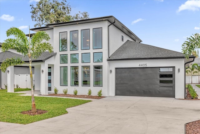 modern home featuring a front yard and a garage