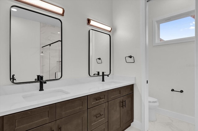 bathroom with vanity, a shower with shower door, and toilet