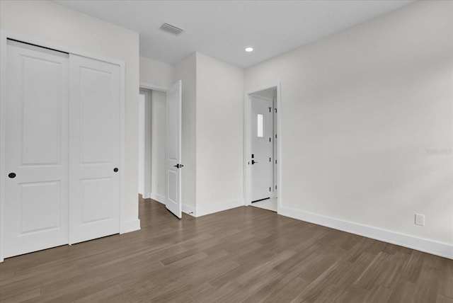 unfurnished bedroom featuring a closet and dark hardwood / wood-style floors