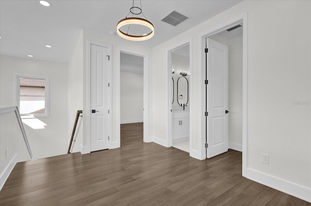 interior space with dark wood-type flooring and ensuite bathroom