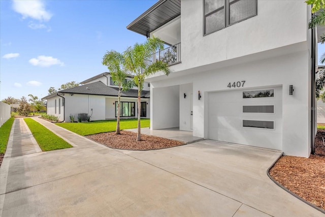 entrance to property with a balcony, a garage, a lawn, and central air condition unit