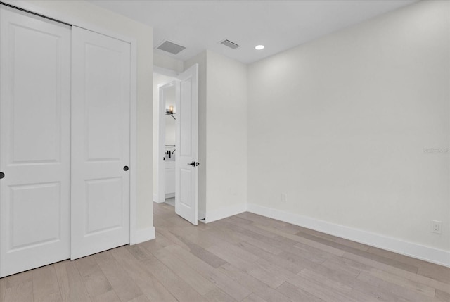 unfurnished bedroom featuring light hardwood / wood-style flooring and a closet