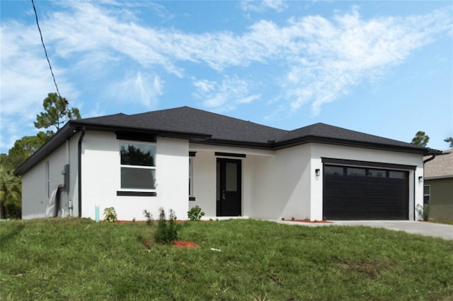 prairie-style home featuring a garage and a front lawn