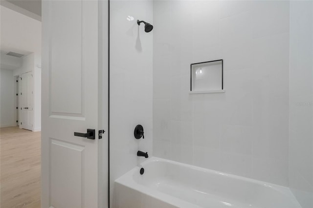 bathroom featuring hardwood / wood-style floors and tiled shower / bath combo