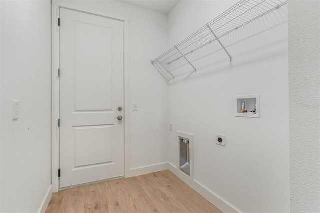 clothes washing area featuring hookup for an electric dryer, washer hookup, and light hardwood / wood-style flooring