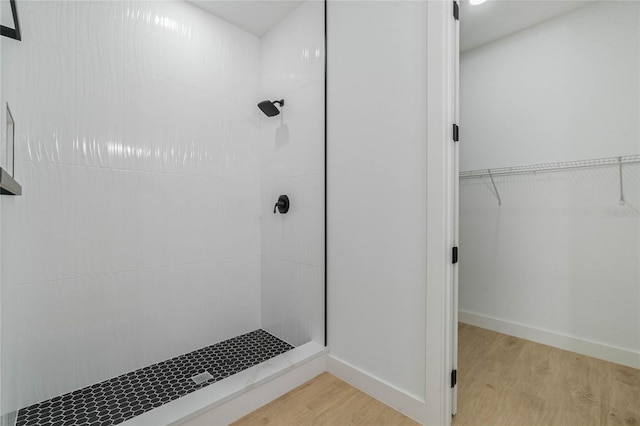 bathroom featuring a tile shower and hardwood / wood-style flooring