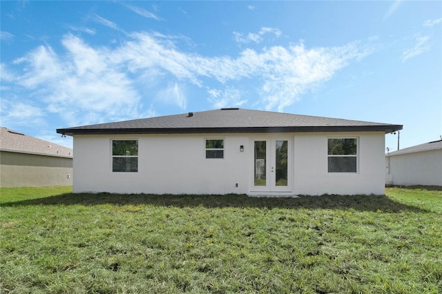 back of property featuring french doors and a lawn