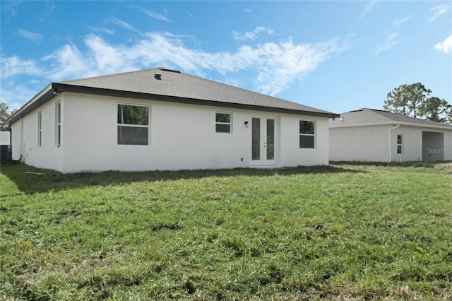 rear view of property featuring a yard and french doors