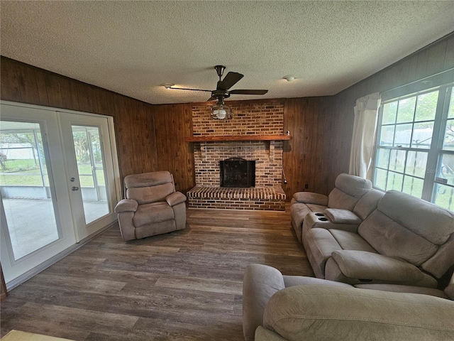 living room featuring wooden walls, a wealth of natural light, hardwood / wood-style floors, and a textured ceiling