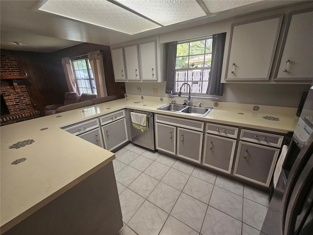 kitchen featuring kitchen peninsula, appliances with stainless steel finishes, gray cabinets, and sink