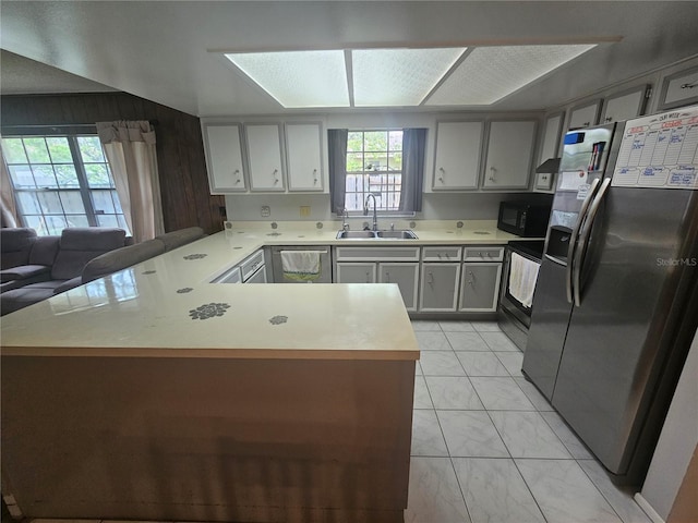 kitchen with stainless steel appliances, gray cabinets, sink, and kitchen peninsula