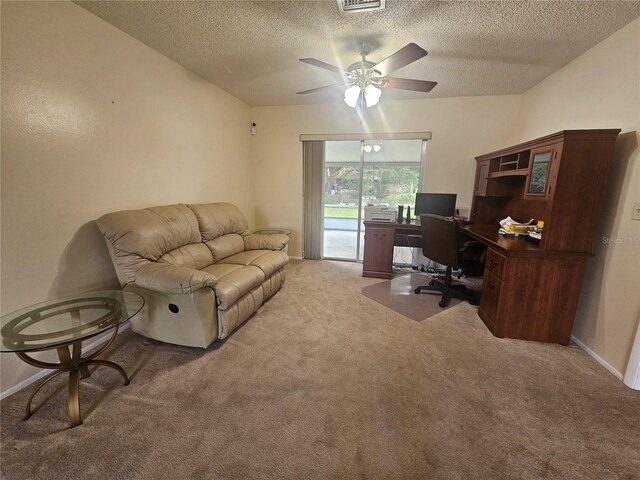 carpeted office space featuring a textured ceiling and ceiling fan