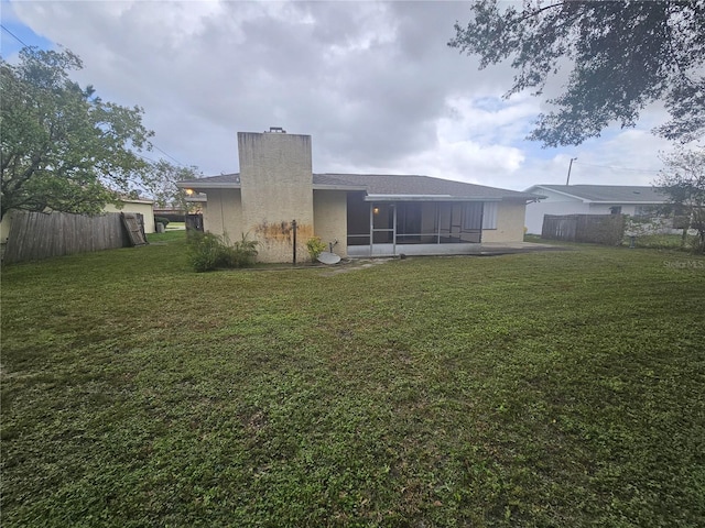 back of house featuring a sunroom and a yard