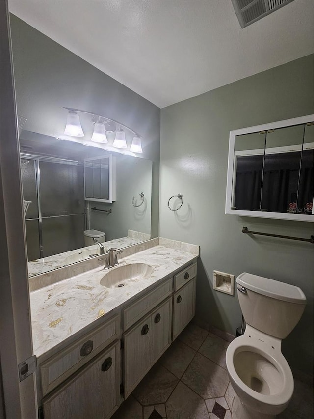 bathroom featuring toilet, vanity, and tile patterned flooring