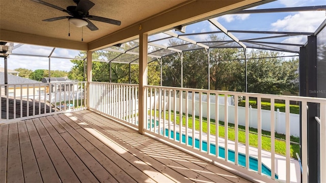 wooden terrace with a lawn and ceiling fan