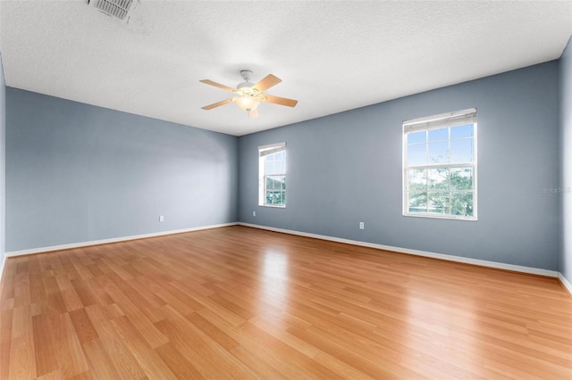 unfurnished room with a textured ceiling, light hardwood / wood-style flooring, and ceiling fan