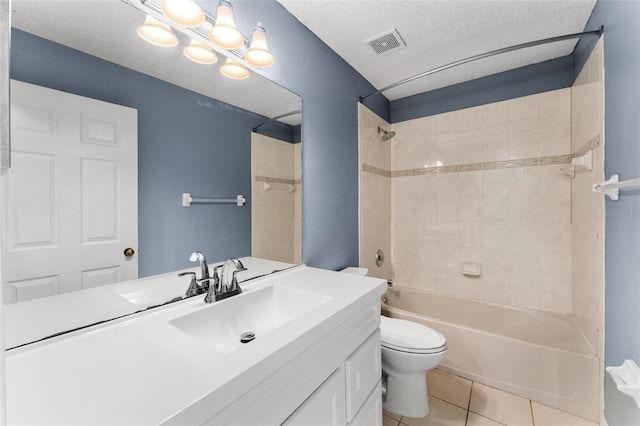 full bathroom featuring tiled shower / bath combo, tile patterned flooring, a textured ceiling, toilet, and vanity