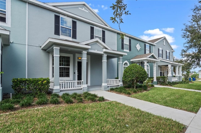 view of front of home featuring covered porch and a front lawn