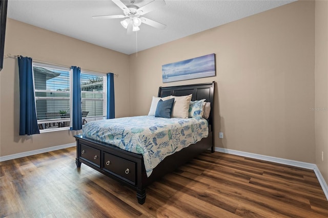 bedroom with ceiling fan, dark hardwood / wood-style flooring, and a textured ceiling