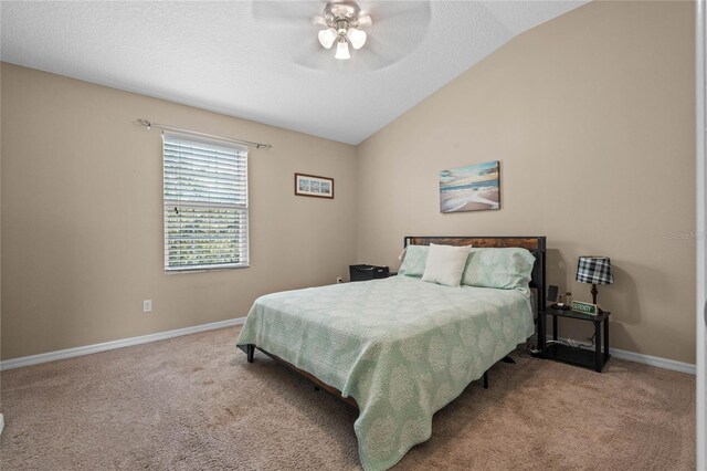 bedroom featuring light carpet, a textured ceiling, vaulted ceiling, and ceiling fan