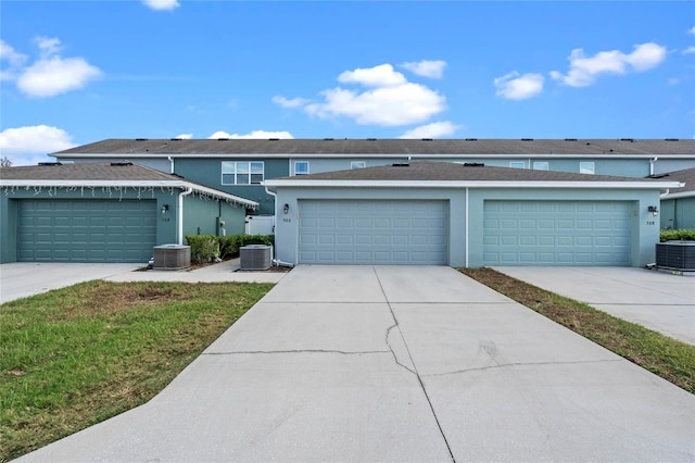 view of front of home with central AC unit and a garage